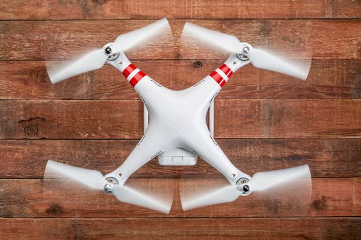 Fort Collins, CO, USA - March 17, 2015:  DJI Phantom 2 with spinning propellers, top view against rustic wooden wood table