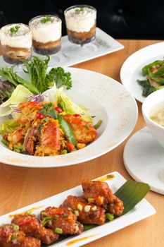 Varieties of Thai foods and appetizers covering a table. Shallow depth of field.