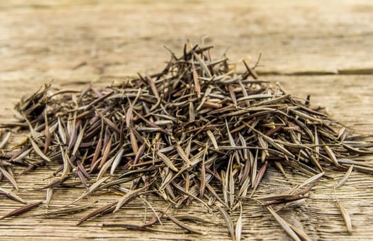 A pile of marigold seeds is ready to plant in a spring garden on wooden background