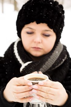 woman with cup of coffee in the winter park. For your commercial and editorial use.