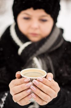 woman with cup of coffee in the winter park. For your commercial and editorial use.