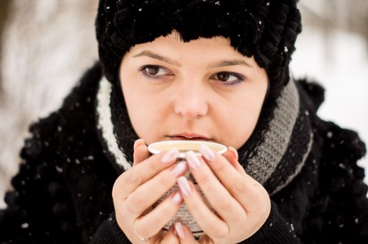 woman with cup of coffee in the winter park. For your commercial and editorial use.