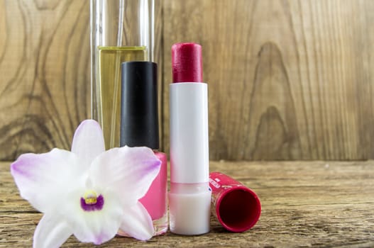 cosmetics and flowers on table on wooden background