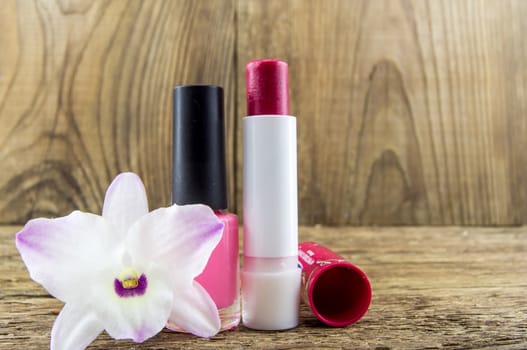 cosmetics and flowers on table on wooden background