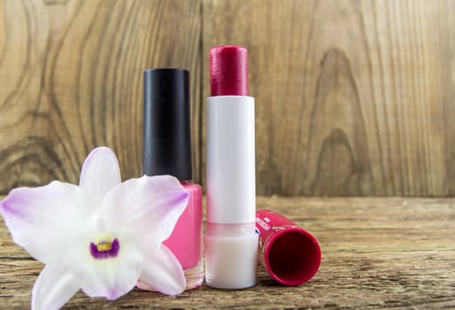 cosmetics and flowers on table on wooden background