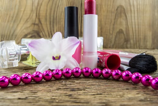 cosmetics and flowers on table on wooden background