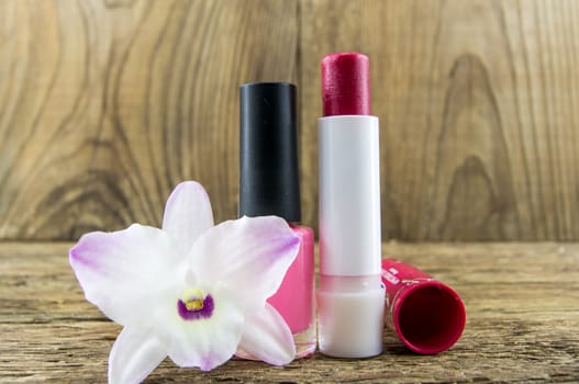 cosmetics and flowers on table on wooden background