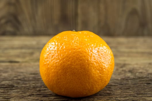 Ripe tangerines lie on a wooden background