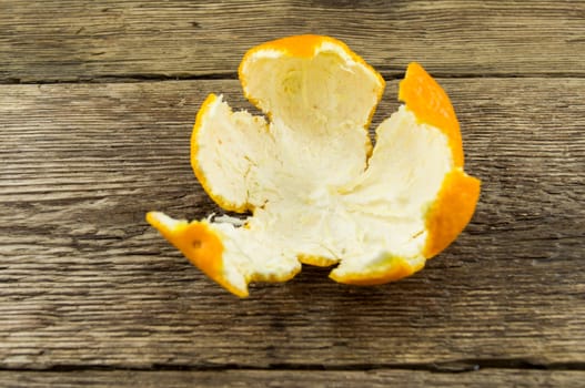 Ripe tangerines lie on a wooden background.