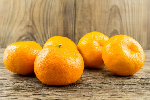 Ripe tangerines lie on a wooden background