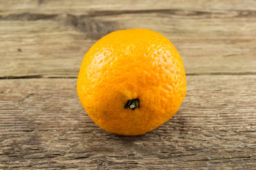 Ripe tangerines lie on a wooden background.