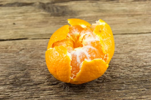 Ripe tangerines lie on a wooden background.