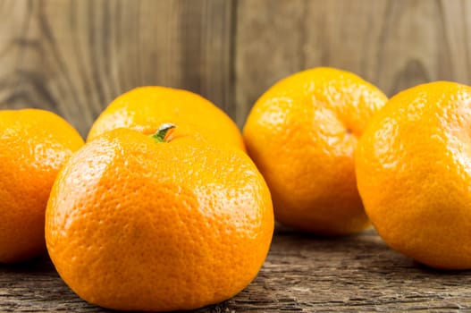 Ripe tangerines lie on a wooden background