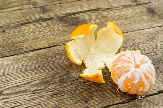 Ripe tangerines lie on a wooden background.