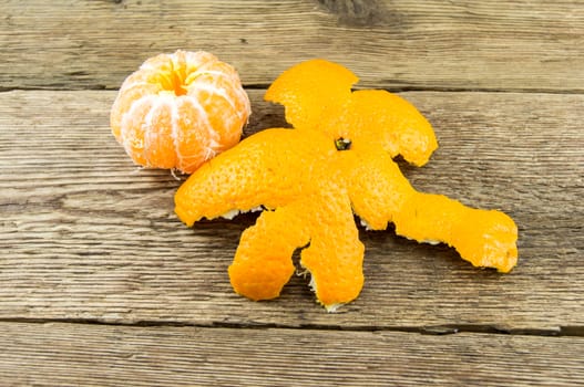 Ripe tangerines lie on a wooden background.