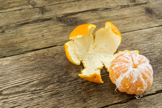 Ripe tangerines lie on a wooden background.