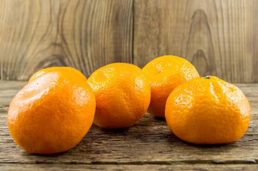 Ripe tangerines lie on a wooden background