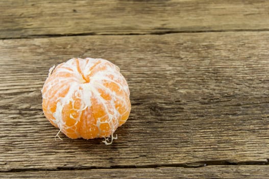 Ripe tangerines lie on a wooden background.