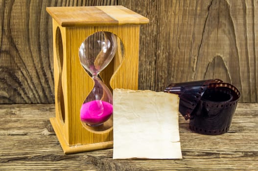 Hourglass with space for text on the wooden background.