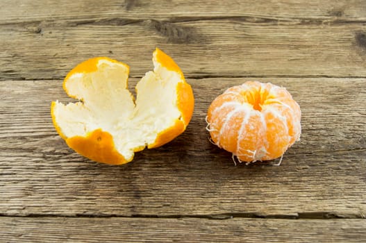 Ripe tangerines lie on a wooden background.