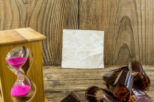 Hourglass with space for text on the wooden background.