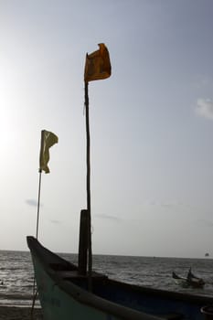 Old fishing boat standing on the sandy beach. India, Goa.