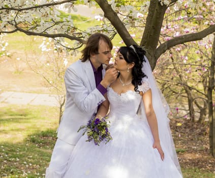 Bride and groom with a bouquet of kisses on the nature.