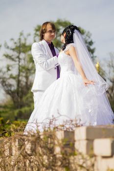 Elegant bride and groom posing together outdoors on a wedding day