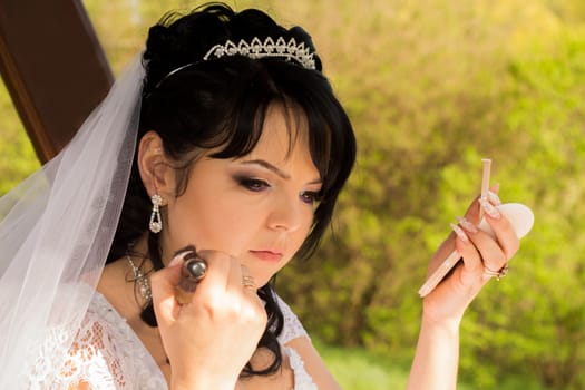 young bride is doing makeup. For your commercial and editorial use.