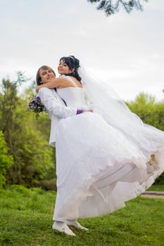 Groom and Bride in a park. wedding dress. Bridal wedding bouquet of flowers