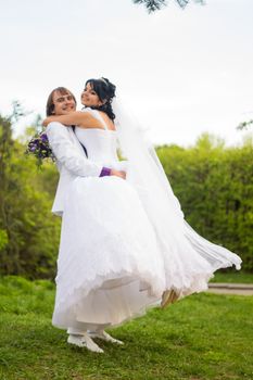 Groom and Bride in a park. wedding dress. Bridal wedding bouquet of flowers