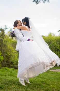 Groom and Bride in a park. wedding dress. Bridal wedding bouquet of flowers