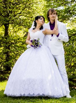 Elegant bride and groom posing together outdoors on a wedding day