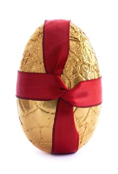 Gold easter egg covered in foil with a red silk ribbon