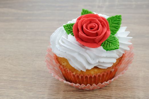 Muffin with butter cream decorated   red sugar rose