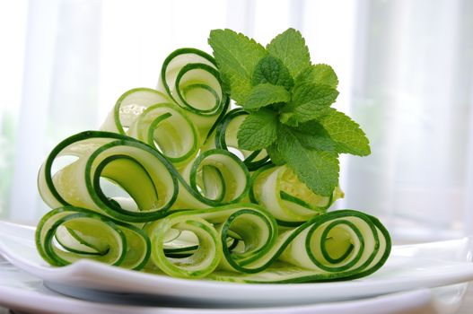 Salad cucumber ribbons twisted in rolls with mint