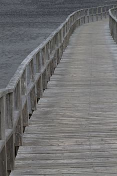 Winding oceanside boardwalk traverses into distance, symbolic of wandering and leisure.  Location is 1 km long, Old Day's Pond Boardwalk, Bonavista, Newfoundland and Labrador, Canada.  