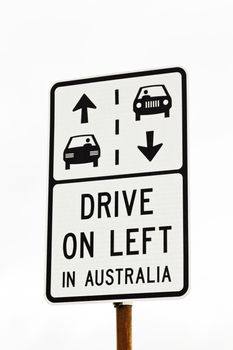 White and black sign indicating "Drive on Left in Australia" traffic regulation, an important distinction to American travelers and tourists. 