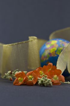 Selective focus on spring globe mallow flowers with festive symbol of world behind reflects fresh nature of travel, whether for pleasure, business, or adventure.