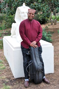 Muslim jazz musician with his saxophone outside.