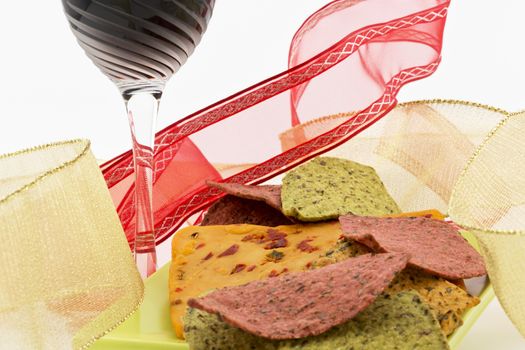 Lively and festive image of red and gold ribbons with ethnic flavors in party foods of cheese with chili and pepper and healthy tortilla chips in green and red vegetable flavors and colors.  