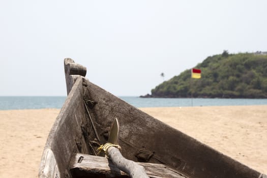 Old fishing boat standing on the sandy beach. India, Goa.