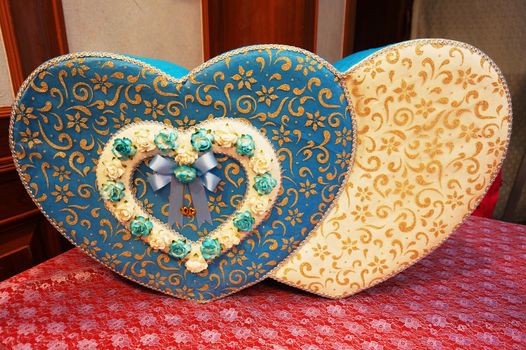 Heart shaped wedding envelope box placed on table that coverd with red cloth.                         