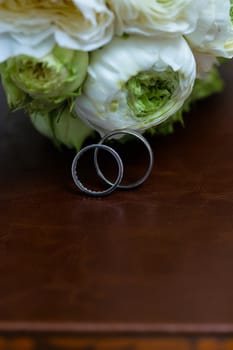 Bouquet of white roses and silver wedding rings