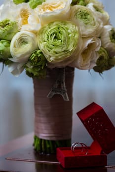 Bouquet of white roses and silver wedding rings