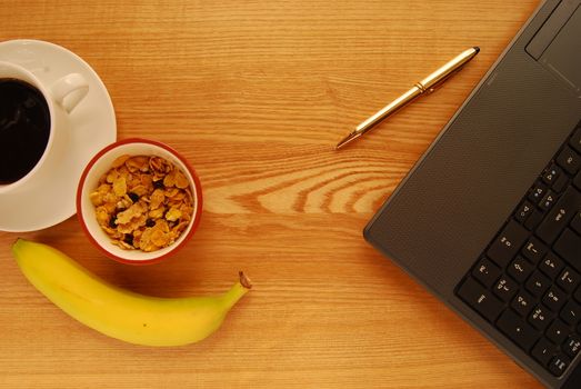 Breakfast at the Desk of a Busy Office Worker, Including Cereal, Banana and Coffee