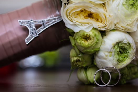 Bouquet of white roses and silver wedding rings