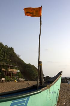 Old fishing boat standing on the sandy beach. India, Goa.