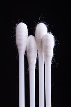 White cotton swabs on black background.