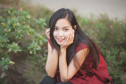 beautiful girl is smiling with red suit in the nature park.